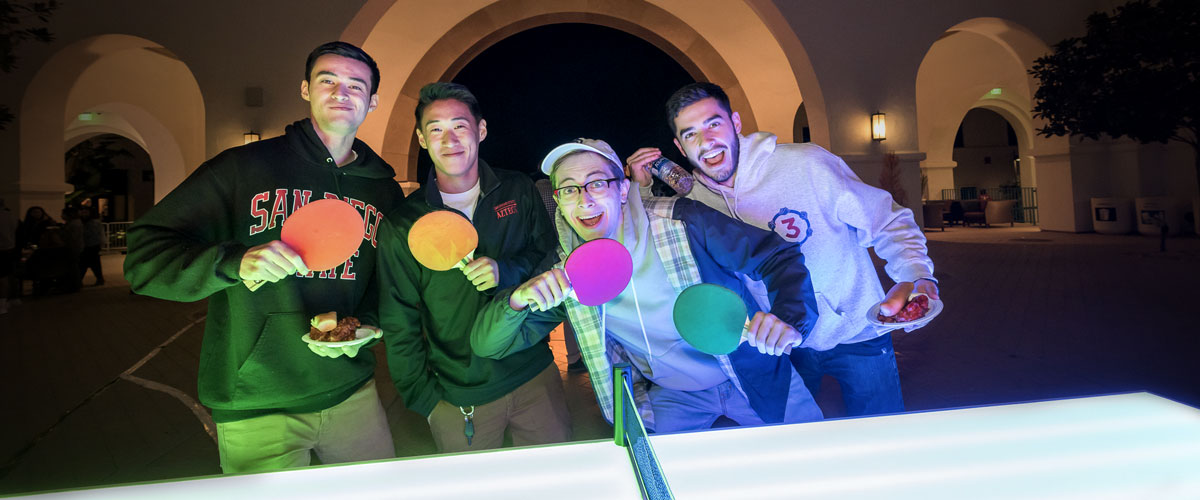 Group shot of six smiling students at Aztec Nights event